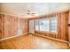 Bright living room with wood-paneled walls, a ceiling fan, and large windows offering plenty of natural light at 802 E Harrison Ave, Gastonia, NC 28054