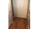 Hallway with hardwood floors, white trim, and large white closet doors at 8540 Indian Summer Trl, Harrisburg, NC 28075