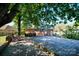 Expansive backyard features a large wooden deck, lush trees, and a charming brick patio area at 1018 Carysbrook Ln, Charlotte, NC 28217