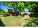 Picturesque backyard featuring a lush lawn, mature trees, and a brick retaining wall at 1018 Carysbrook Ln, Charlotte, NC 28217