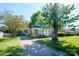 Charming one story brick home with inviting entrance, mature trees, and lush green lawn at 1018 Carysbrook Ln, Charlotte, NC 28217