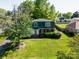 Charming two-story home with a green roof and manicured lawn, framed by mature trees at 1018 Carysbrook Ln, Charlotte, NC 28217