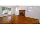 Sunlit living room with a decorative brick fireplace and hardwood floors at 1018 Carysbrook Ln, Charlotte, NC 28217