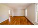 Spacious living room featuring gleaming hardwood floors, neutral paint and abundant natural light at 1018 Carysbrook Ln, Charlotte, NC 28217