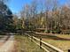 Open grassy area with a split rail fence and wooded backdrop at 124 Lee Mccurry Rd, Lincolnton, NC 28092