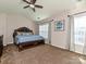 Spacious main bedroom with a tray ceiling, ceiling fan, carpet flooring, and lots of natural light at 14121 Winford Ln, Charlotte, NC 28262