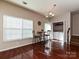 Bright dining room with hardwood floors, chandelier, and a laundry closet in the background at 14121 Winford Ln, Charlotte, NC 28262