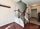 Inviting entryway featuring rich hardwood floors, a staircase with wooden railings and coat rack detail at 14121 Winford Ln, Charlotte, NC 28262