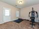 A home gym equipped with workout machine, weights and ample room, complemented by natural light at 14121 Winford Ln, Charlotte, NC 28262