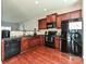 Well-lit kitchen featuring wood cabinets, black appliances including a dishwasher, and a modern backsplash at 14121 Winford Ln, Charlotte, NC 28262