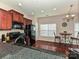 Cozy kitchen features dark wood cabinetry, black appliances, and a granite countertop bar with a breakfast table at 14121 Winford Ln, Charlotte, NC 28262
