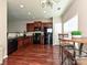 Kitchen with dark wood cabinets, black appliances, breakfast table, and wood floors, providing a cozy eat-in space at 14121 Winford Ln, Charlotte, NC 28262
