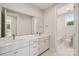 Bright bathroom featuring double sinks, white cabinets, and a separate toilet room for added convenience at 15009 Brownleigh Ln # 26, Huntersville, NC 28078