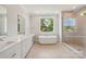 Luxurious bathroom with double vanity, soaking tub, and glass-enclosed shower, providing a spa-like experience at 15009 Brownleigh Ln # 26, Huntersville, NC 28078