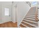 Bright entryway featuring hardwood floors, a staircase with wooden treads, and white trim at 15009 Brownleigh Ln # 26, Huntersville, NC 28078