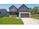 Two-story modern home with a gray exterior, stone accents, a two-car garage and manicured lawn at 15009 Brownleigh Ln # 26, Huntersville, NC 28078