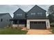 Modern two-story home with black siding, stone accents, and a covered front porch, creating a striking curb appeal at 15009 Brownleigh Ln # 26, Huntersville, NC 28078