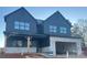 Two-story home showcasing a modern design with a two-car garage and a covered front porch at 15009 Brownleigh Ln # 26, Huntersville, NC 28078