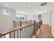 Bright hallway featuring hardwood floors, wrought iron railings, and ample natural light streaming through large windows at 15009 Brownleigh Ln # 26, Huntersville, NC 28078