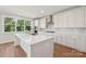 Beautiful bright kitchen with white cabinets, island, stainless steel appliances, and a window view at 15009 Brownleigh Ln # 26, Huntersville, NC 28078