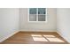Bright room with wood flooring, white walls, white trim, and a large window for natural lighting at 15009 Brownleigh Ln # 26, Huntersville, NC 28078