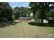 Expansive backyard featuring a home with a deck, lush lawn, mature trees, and shed at 2427 Rhyneland St, Gastonia, NC 28054