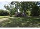 Inviting brick home featuring a spacious yard, mature trees, and a storage shed on the property at 2427 Rhyneland St, Gastonia, NC 28054