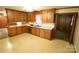 Eat-in kitchen with wood cabinets, a double sink, and doorway to another room at 2427 Rhyneland St, Gastonia, NC 28054