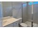 Well-lit bathroom featuring a glass shower, gray tile, and vanity with quartz countertop at 5540 Stafford Rd # 31, Charlotte, NC 28215