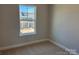 Bright bedroom with neutral carpet and walls, a window overlooking the neighborhood at 5540 Stafford Rd # 31, Charlotte, NC 28215