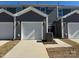 Modern townhome exterior featuring gray siding, white garage doors, and well-maintained landscaping at 5540 Stafford Rd # 31, Charlotte, NC 28215