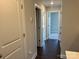 Hallway with hardwood floors and neutral paint leading to bedrooms at 5540 Stafford Rd # 31, Charlotte, NC 28215