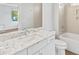 Modern bathroom with granite countertop, white cabinets, and a bathtub at 916-A Westbrook Dr, Charlotte, NC 28202