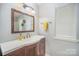 Simple bathroom with single vanity, mirror, and yellow hand towel at 15450 Millview Trace Ln, Mint Hill, NC 28227