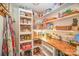 Well-organized pantry with wood countertop, full of storage and shelving space for food items at 15450 Millview Trace Ln, Mint Hill, NC 28227