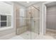 Elegant bathroom with glass shower enclosure, built-in bench and natural light shining in from the window at 4440 Moxie Way, Charlotte, NC 28215