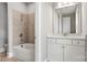 Bathroom featuring a tiled shower and tub, a white vanity with a white countertop and brass faucet at 4440 Moxie Way, Charlotte, NC 28215