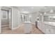 Bright kitchen featuring a large island, white cabinets, stainless steel appliances, and hardwood floors at 4440 Moxie Way, Charlotte, NC 28215