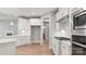 Modern kitchen with white cabinetry, stainless steel appliances, hardwood floors and white tiled backsplash at 4440 Moxie Way, Charlotte, NC 28215