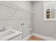 Functional laundry room with utility sink, shelving and window at 4440 Moxie Way, Charlotte, NC 28215