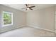 Bright bedroom featuring carpet, ceiling fan and a large window overlooking nature at 8021 Joy Crossing Ln, Charlotte, NC 28214
