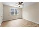 Bright bedroom featuring neutral paint, a ceiling fan, and a large window at 1916 Irma St, Charlotte, NC 28216