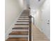 Bright hallway with hardwood floors leads to a staircase with wood treads and a white painted risers at 1916 Irma St, Charlotte, NC 28216