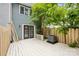 Fenced backyard with a wood deck, a mature tree, and modern exterior at 9424 Lexington Cir # F, Charlotte, NC 28213