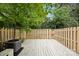 Spacious backyard featuring a wooden deck, privacy fence, and mature trees at 9424 Lexington Cir # F, Charlotte, NC 28213