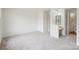 Bright bedroom with neutral carpet and a view of the ensuite bathroom and vanity area at 9424 Lexington Cir # F, Charlotte, NC 28213