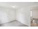 Bright bedroom features neutral carpet, white walls, and entry to the upper level at 9424 Lexington Cir # F, Charlotte, NC 28213
