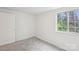 Bedroom featuring carpeted floors, natural light from the window and a white door at 9424 Lexington Cir # F, Charlotte, NC 28213