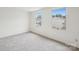Light-filled bedroom with two windows offering neighborhood views, and neutral carpet at 9424 Lexington Cir # F, Charlotte, NC 28213
