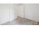 Bedroom with neutral walls and carpet and single door to the hallway at 9424 Lexington Cir # F, Charlotte, NC 28213